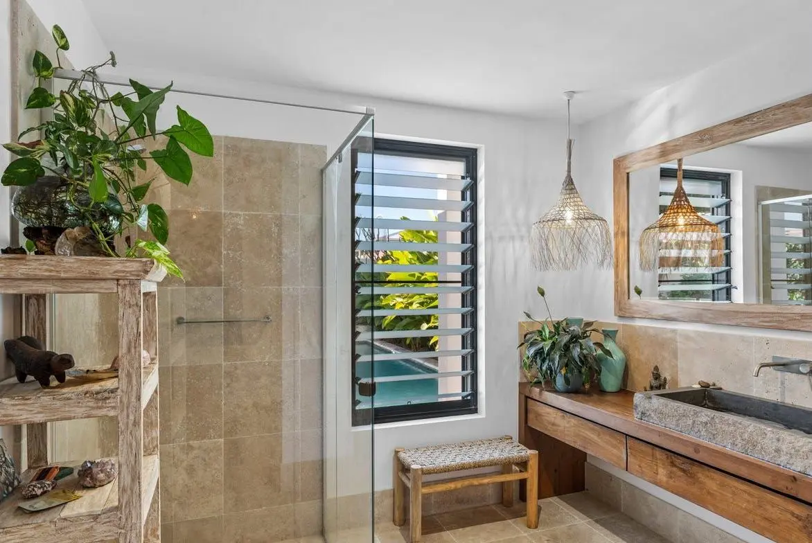 Bathroom with travertine tiles and a louvred window