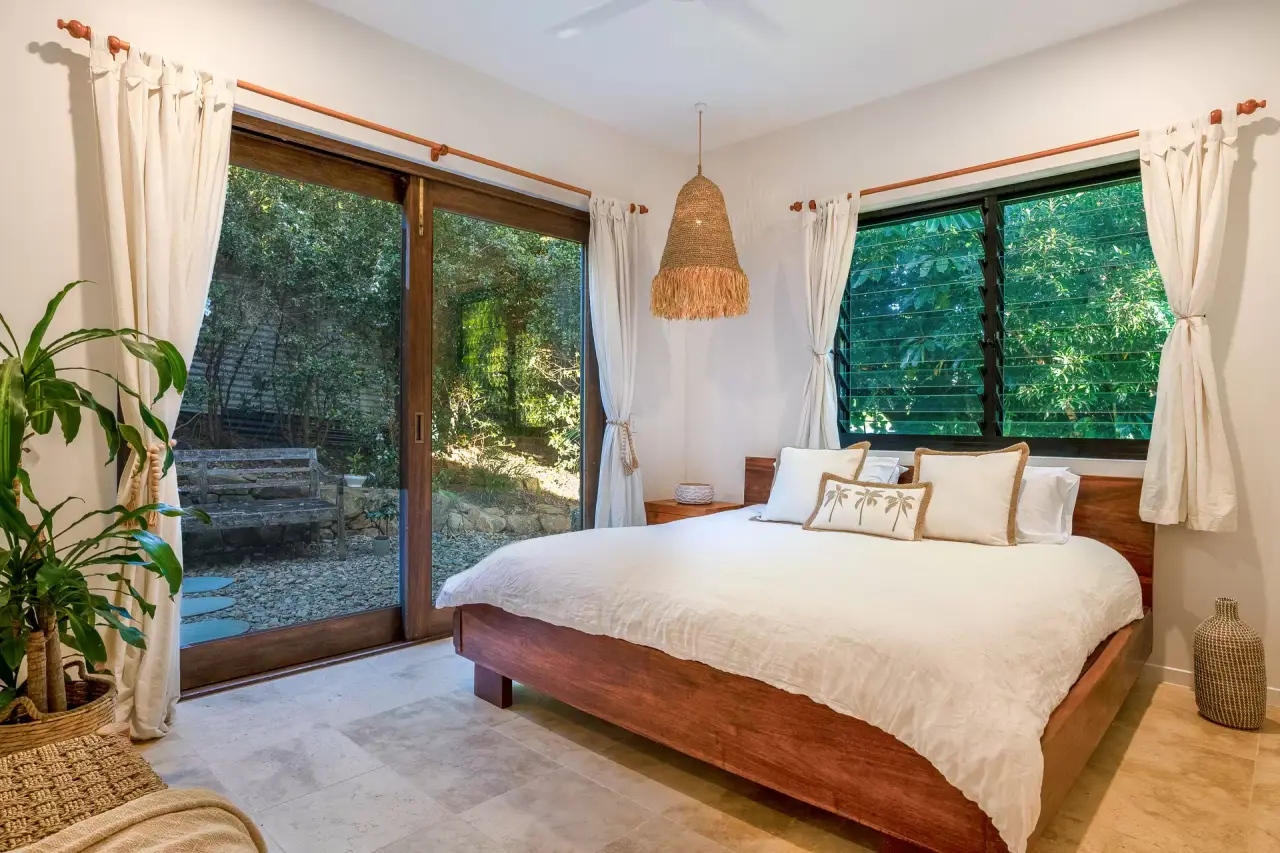 Bedroom with a timber bed and louvred windows