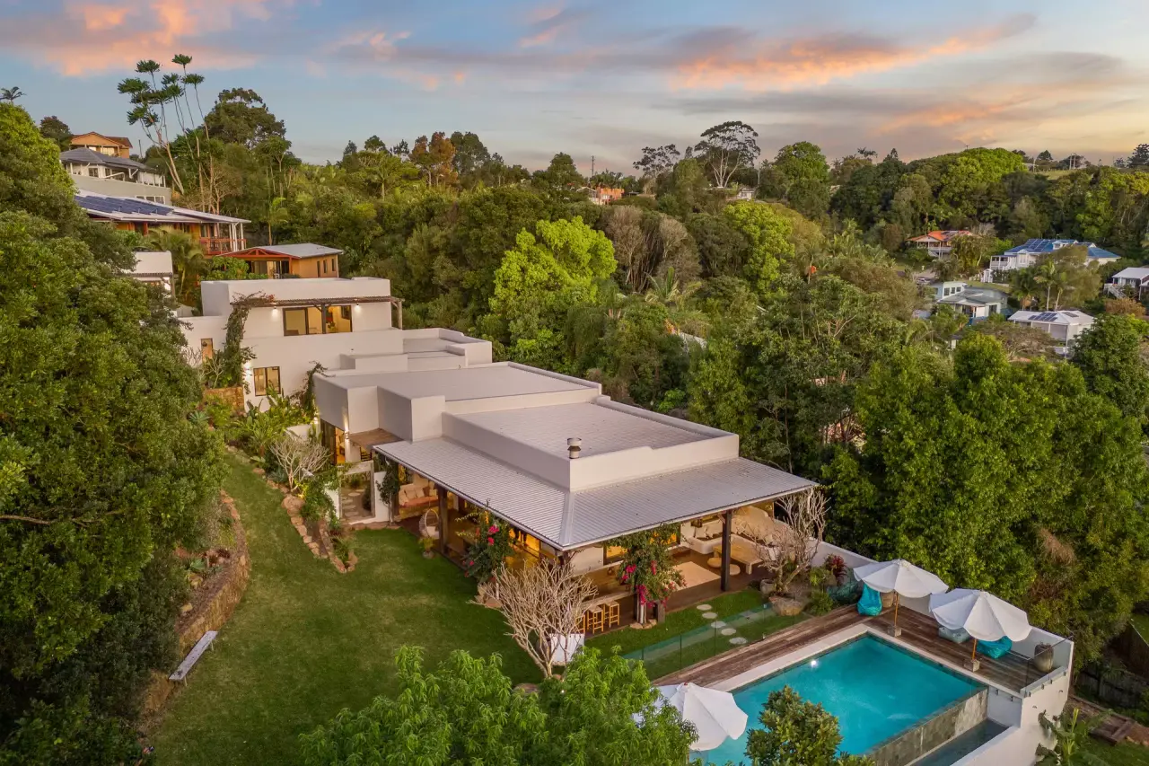 Aerial view at sunset of the house stepping down the garden to the pool