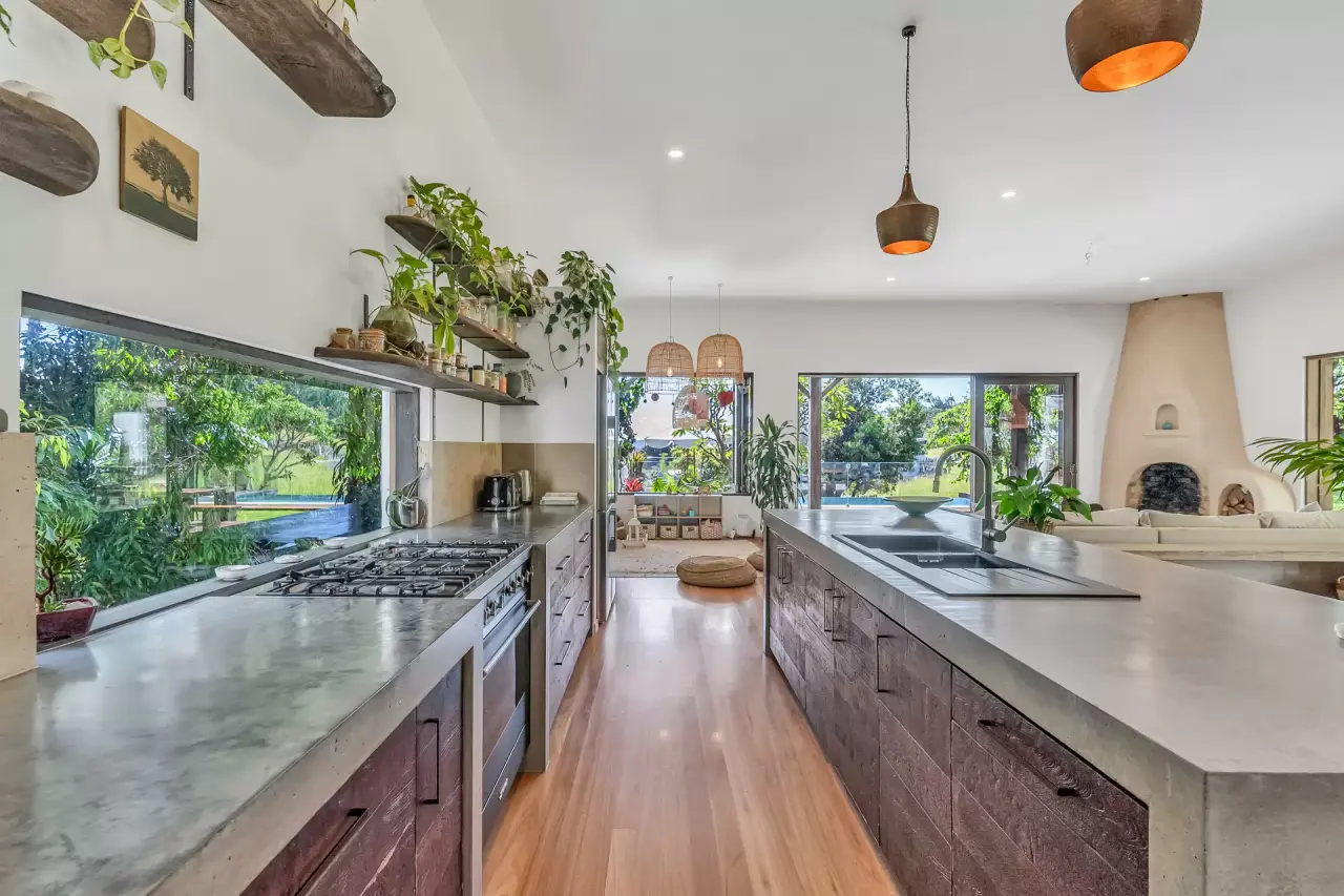 Kitchen with concrete benchtops, timber cabinetry and garden views