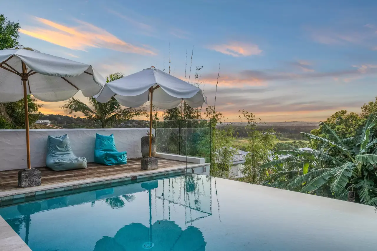 Infinity pool and umbrellas looking west at sunset